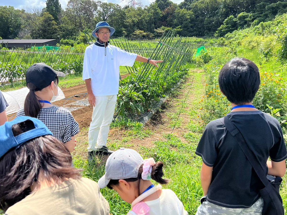 麻生区の畑で農の話を聞く親子